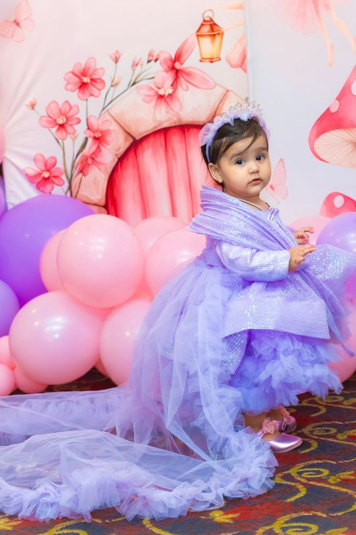 Girl wearing a lavender multi-layered sequin and net birthday dress with a detachable personalized name trail